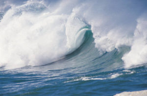 huge wave crashing into shore