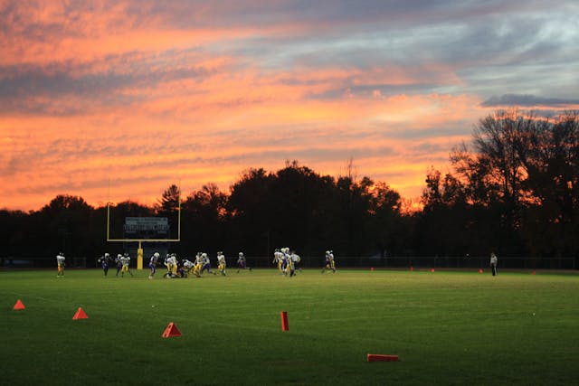 american football players on field at sunset